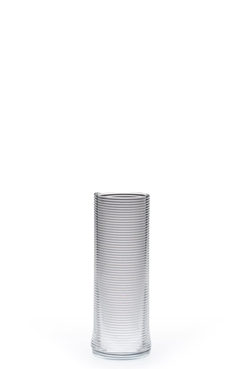 Clear ribbed glass vase, empty, on white with soft reflection