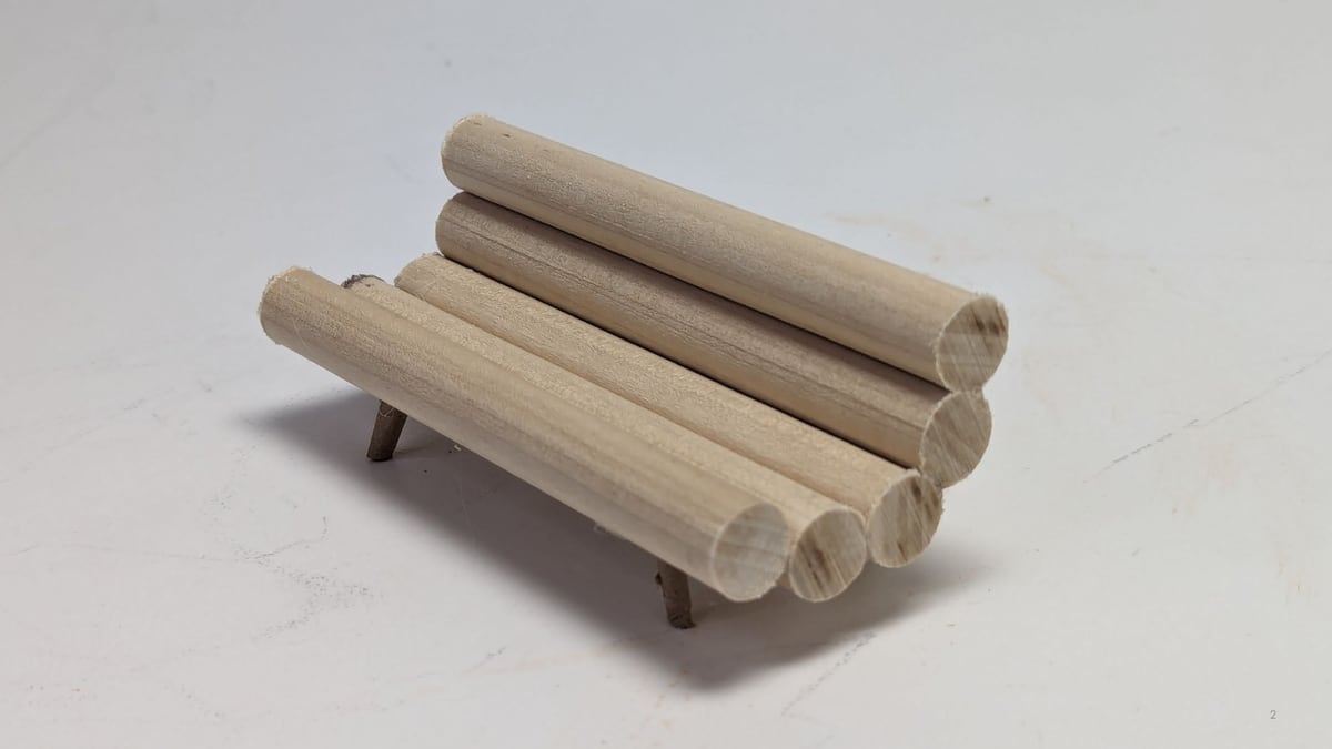 Photo of a small wooden-dowel physical model of the log-style sofa